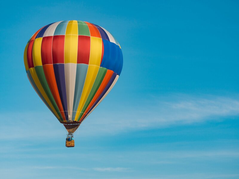 Kleurrijke luchtballon tegen een blauwe lucht.