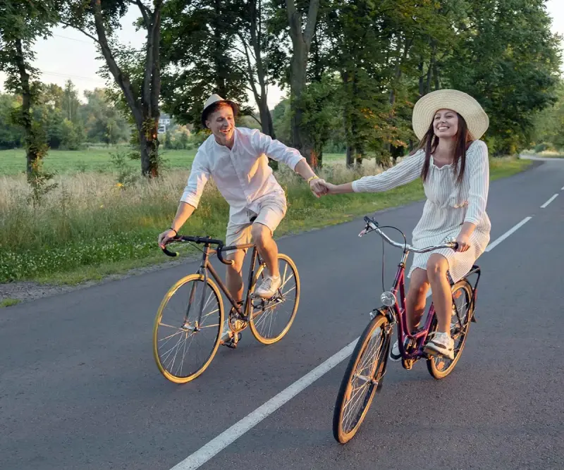 Twee fietsers op een landweg tussen de bomen.