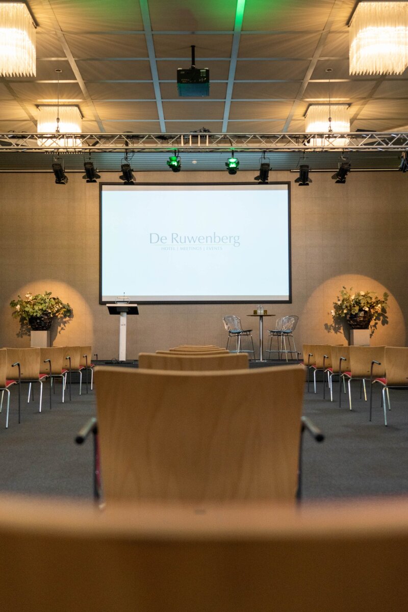 Atrium met sfeervolle gekleurde verlichting tijdens een bijeenkomst.