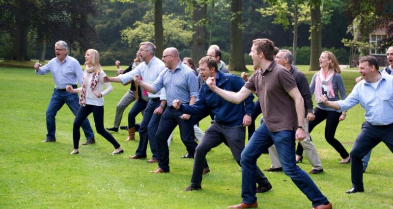 Groep collega's tijdens een haka-workshop in het groen.
