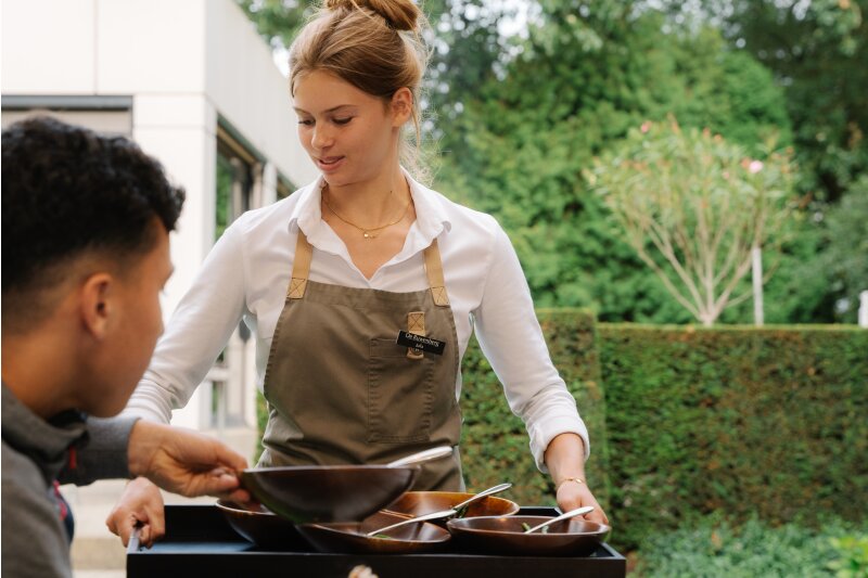 Medewerker bereidt de barbecue voor spelers op het landgoed.